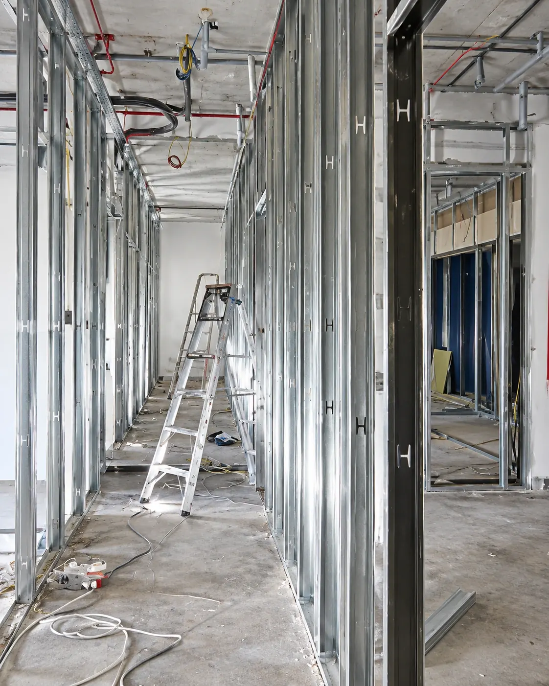 Metal stud framing for gypsum partitions along an office corridor