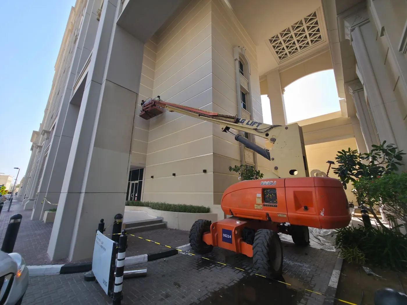 Painters working from a boom lift on the facade of a multi-storey building