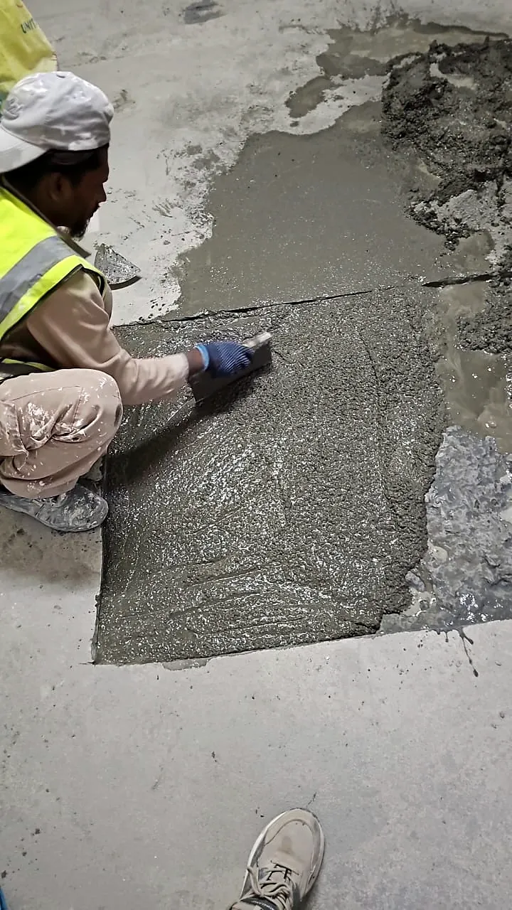 Operative trowelling repair mortar into a prepared patch in a concrete slab