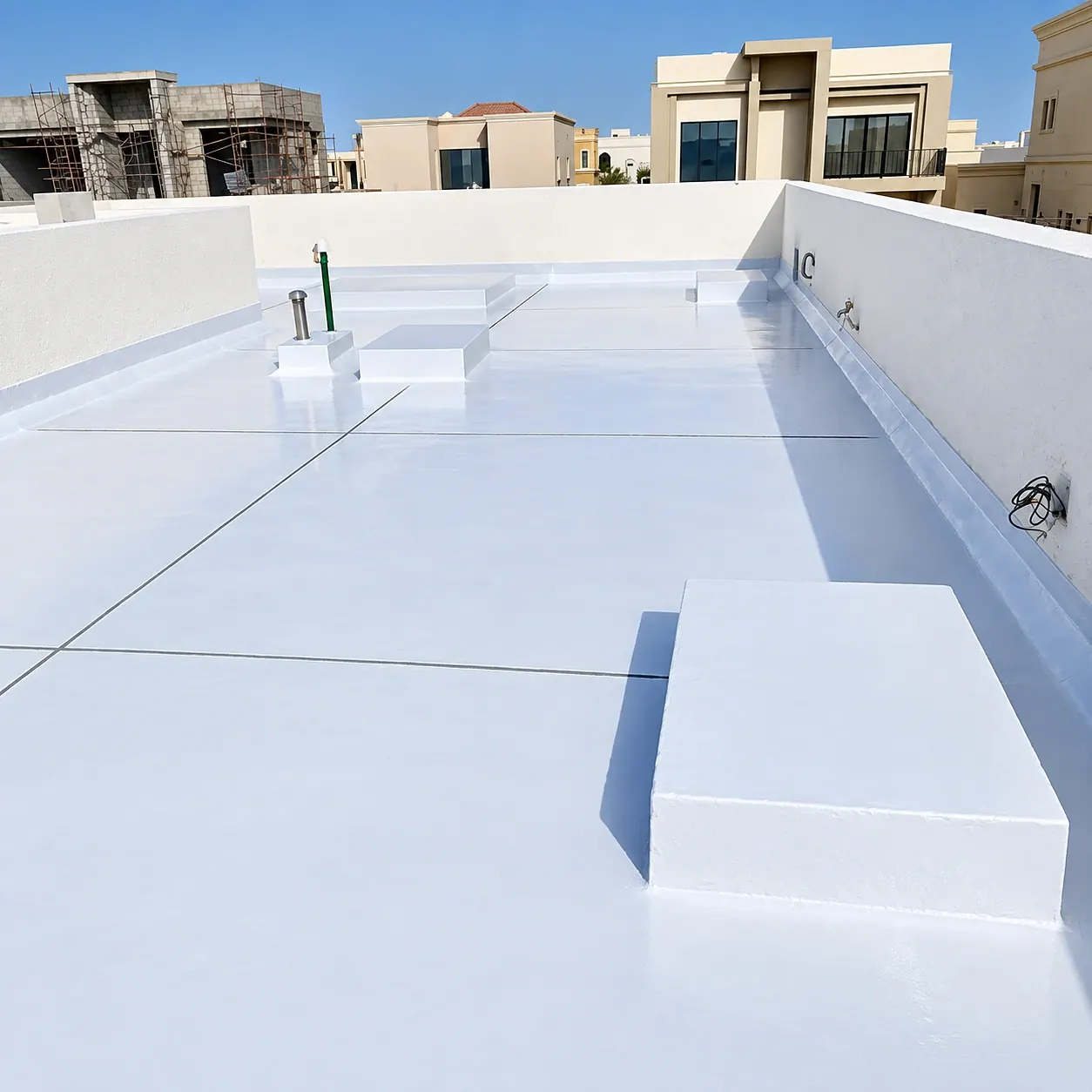 Finished liquid-applied waterproofing membrane on a villa roof, with upstands and plinths fully coated